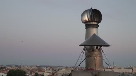 metal chimney rotating and residential area on background