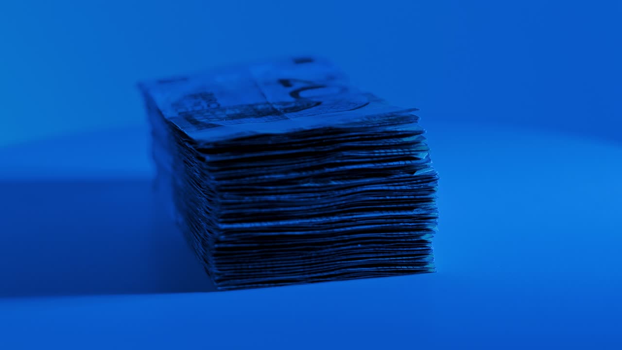 Stylized slow motion euro money shot in cold light suggesting financial power