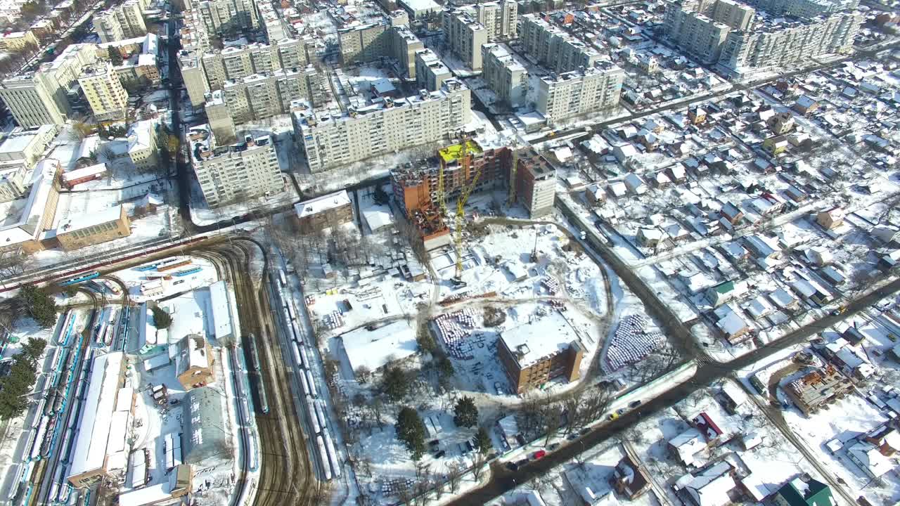 Newly constructed building. Crane and building construction site in winter