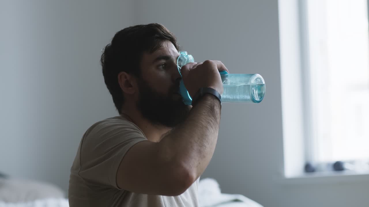 침실에서 물을 마시는 남자