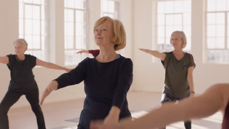 Clase-De-Yoga-Mujer-Madura-Sana-Practicando-Pose-Guerrera-Disfrutando-Del-Entrenamiento-Grupal-En-El-Gimnasio