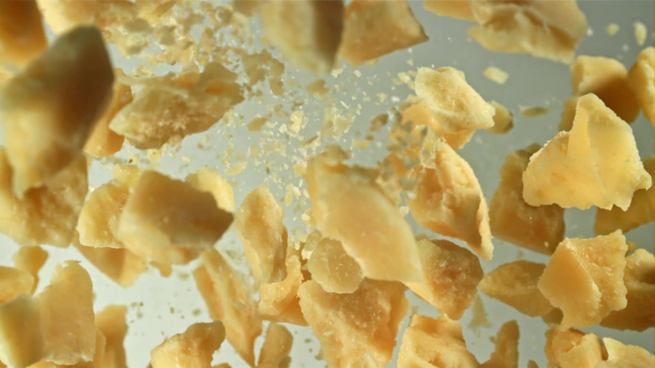 Pezzi di Parmigiano che cadono al rallentatore.