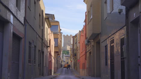 an amazing view of a narrow street near the atalaya castle of villena city, a car moving on the streets, valencia, southeastern spain