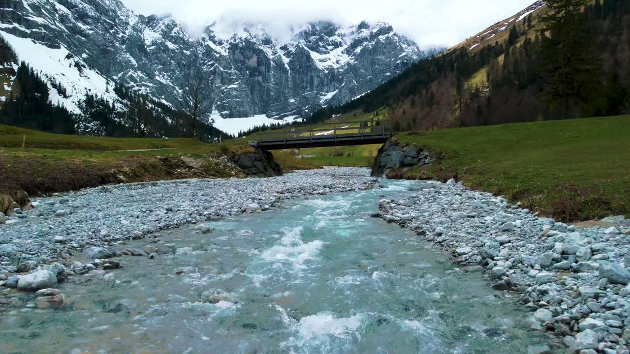 cierra el vuelo de drones aéreos bajos en el pintoresco valle de ahornboden engtal a lo largo del río de montaña rissach en los alpes austriacos bávaros en un día nublado y soleado a lo largo de árboles, rocas, bosques y colinas en la naturaleza
