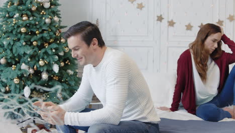 Distracted-man-texting-mobile-in-luxury-house.-Smiling-husband-ignoring-wife