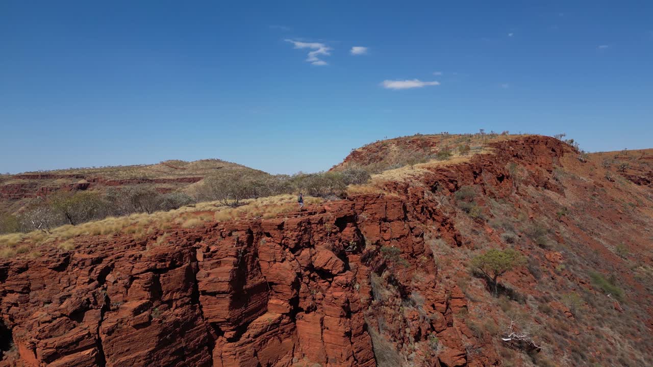 disparo de avión no tripulado cinematográfico que muestra a un excursionista caminando por el borde de un acantilado en australia