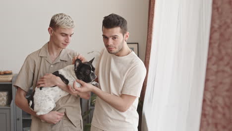 portrait of two gay men petting cute dog