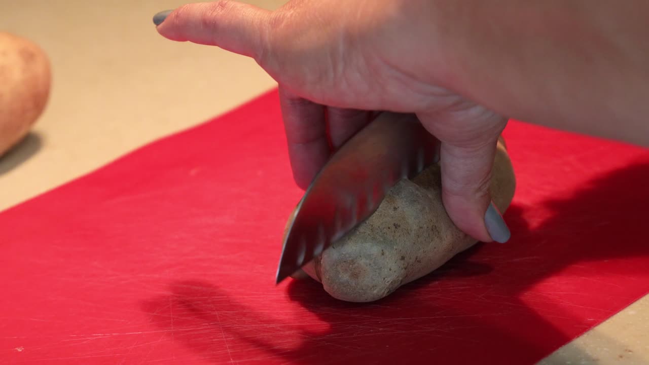 생 감자를 큐브로 자르고 큐브를 그릇에 넣는 여성 손