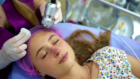 a professional cosmetologist makes facial procedures in a beauty salon. cosmetological innovations. modern technic.