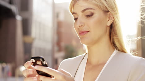 Hermosa-Mujer-Rubia-Usando-El-Concepto-De-Energía-Solar-De-La-Luz-Solar-De-La-Llamarada-Del-Teléfono-Inteligente