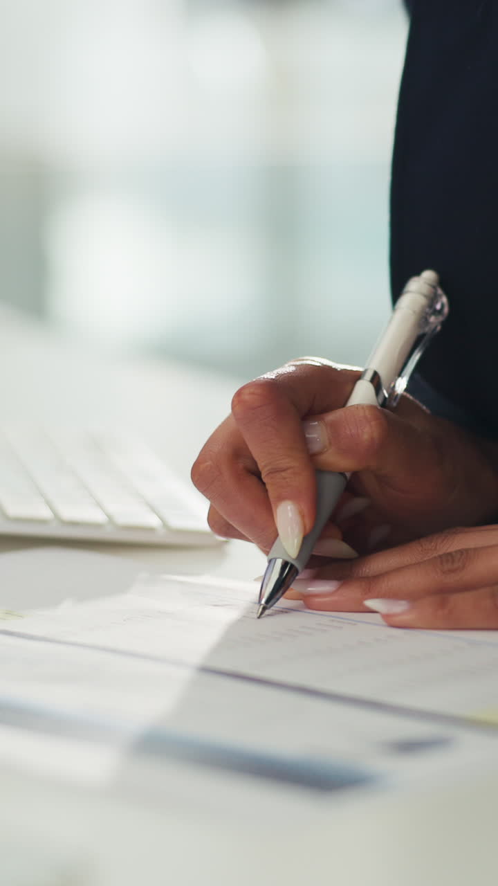 Close-up of Hands Writing on Document and Typing on Keyboard