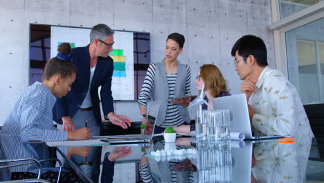 Multi-ethnic-business-people-discussing-over-blueprint-in-the-conference-room-at-modern-office-4-4k