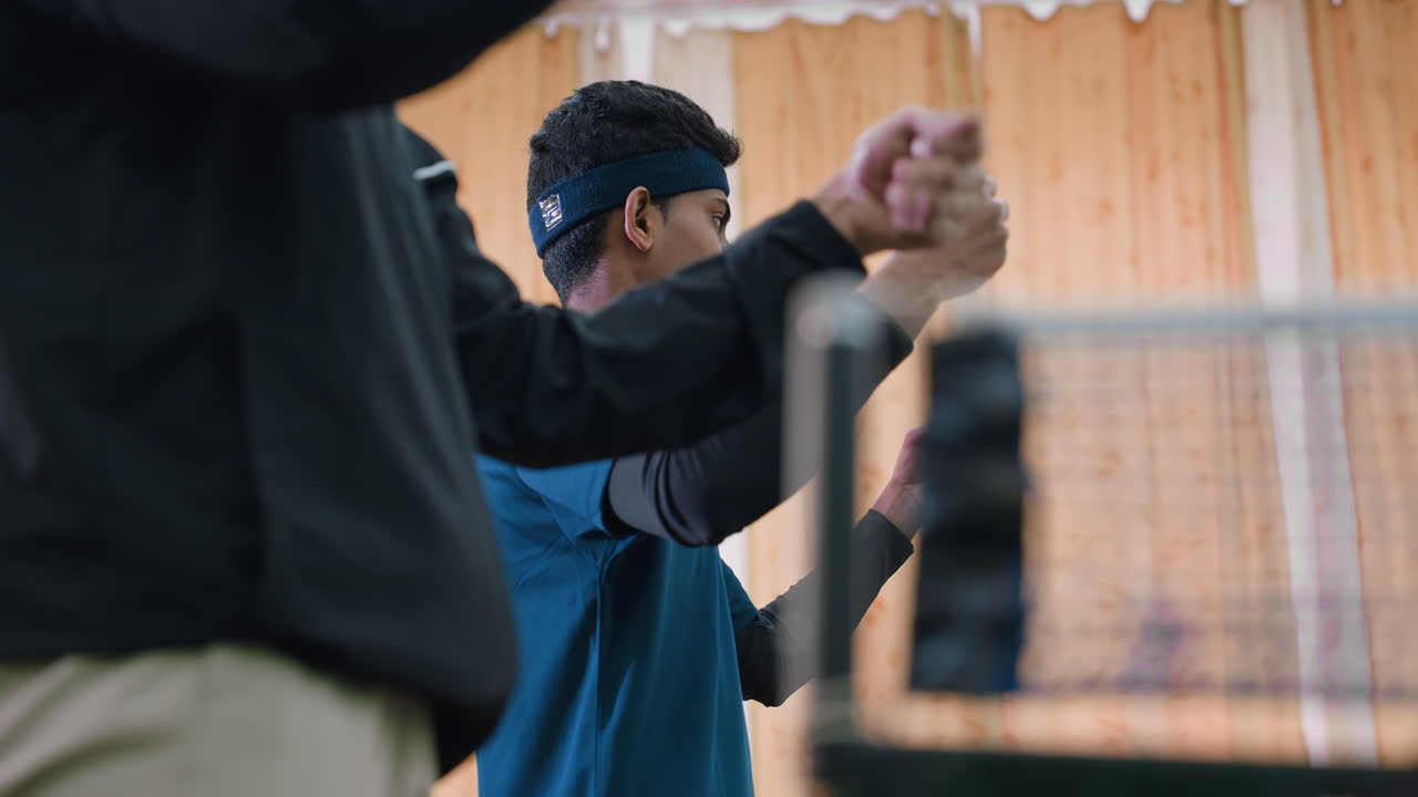 Close up of athletes stretching wrists during indoor training session focusing on flexibility, strength, and preparation for sports performance with blurred background