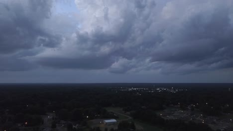 dark storm clouds rolling in over small town, drone angle