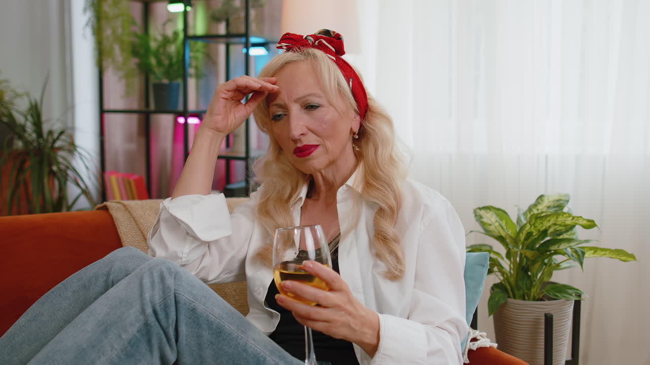 Donna anziana triste e depressa, afflitta da malattie, che beve champagne, con problemi, cattive notizie e bancarotta.