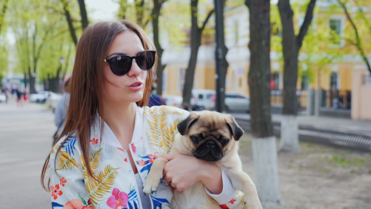 젊은 여자는 도시에서 강아지와 함께 산책