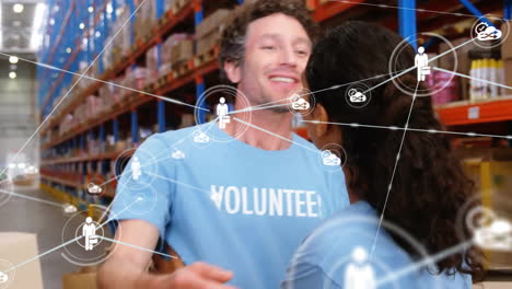 Animation-of-network-of-connections-with-icons-over-diverse-volunteers-working-in-warehouse