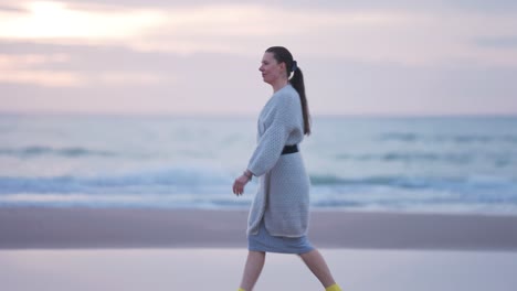 a middle-aged woman walks on the sandy shore