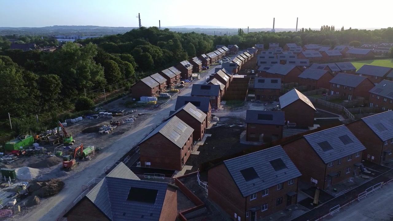 Luftfoto af byggeplads for et overkommeligt nyt boligområde over et ufærdigt kvarter