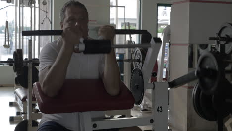 senior man exercising on bicep training machine