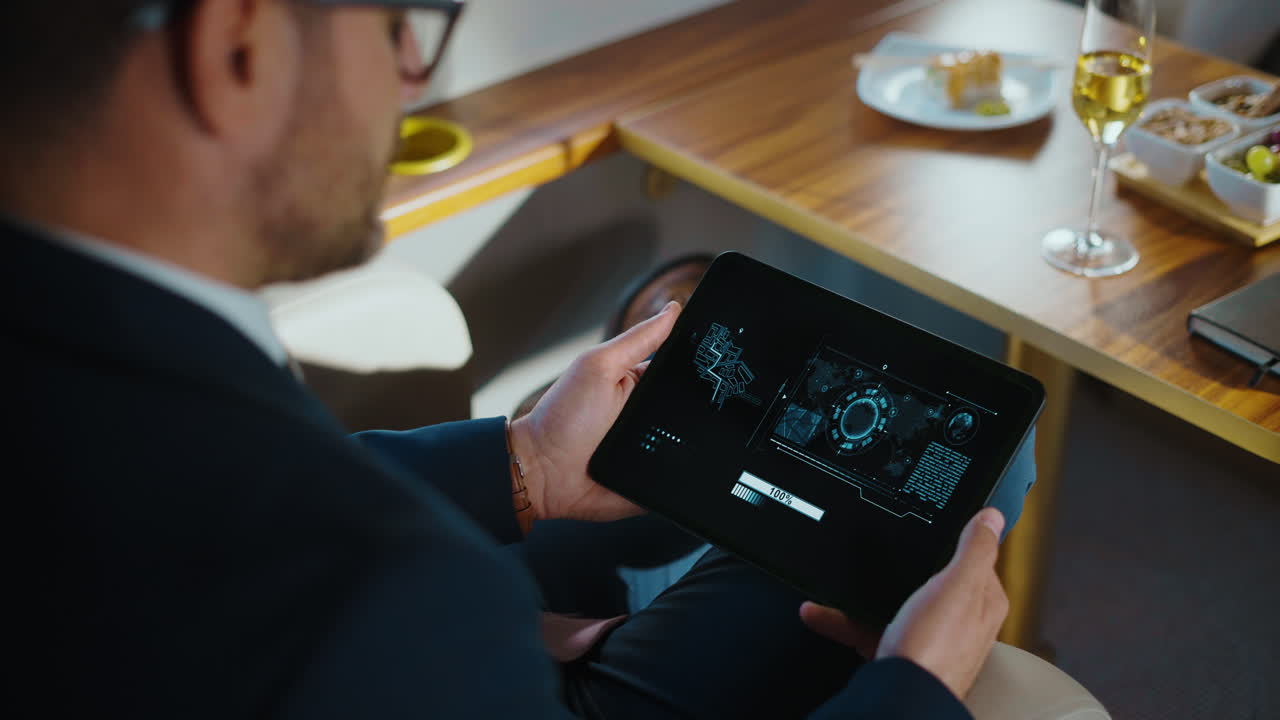 Man Using Tablet in Private Jet with Food and Drink