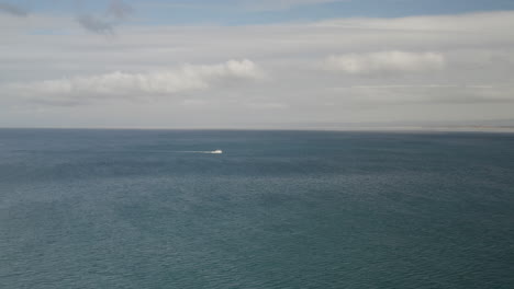 4K-cinematic-drone-shot-of-lone-fishing-boat-crossing-Monterey-Bay-in-California-with-a-single-seagull-moving-through-frame