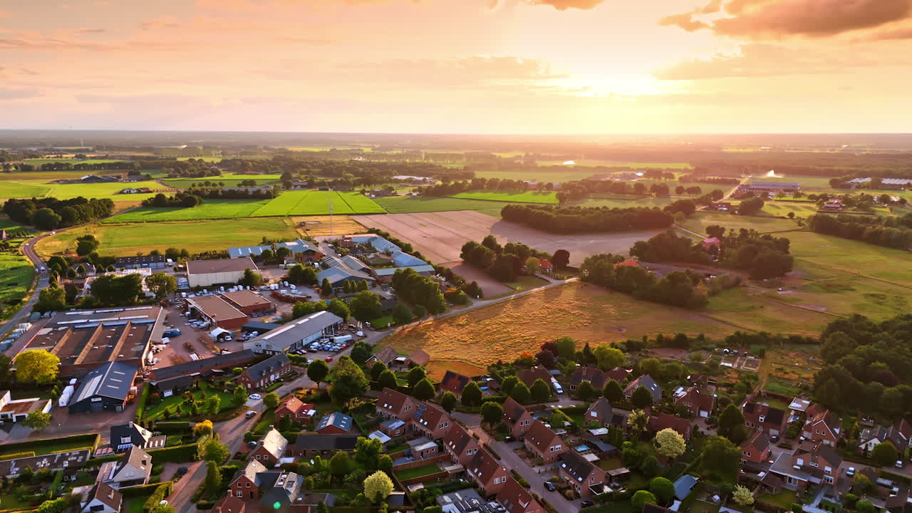 Beautiful golden light of sunset colors the scenery of the town. Drone footage over the countryside in the Netherlands
