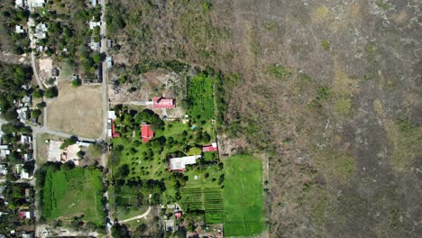 Luftdrohnenaufnahme-Einer-Hacienda-Mit-Grünem-Gras-Und-Der-Stadt-Ake-In-Yucatan