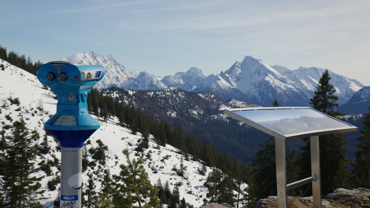 Binoculars At The Viewpoint Overlooking The Snowy Mountains In Winter. Wide shot