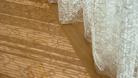 curtains create a beautiful pattern on the wooden floor due to the sun. filmed at home