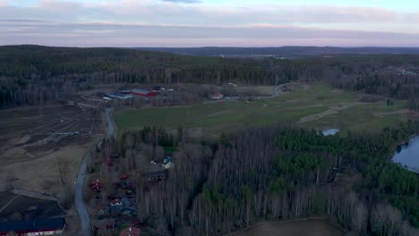 Imágenes-De-Drones-En-órbita-Lenta-Que-Muestran-Un-Campo-De-Golf-Verde-Durante-El-Invierno-Mientras-Revelan-Un-Pequeño-Lago