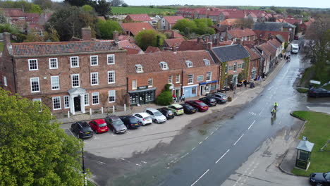 still aerial drone shot of old small village burnham market with cars and cyclists passing by in north norfolk uk east coast