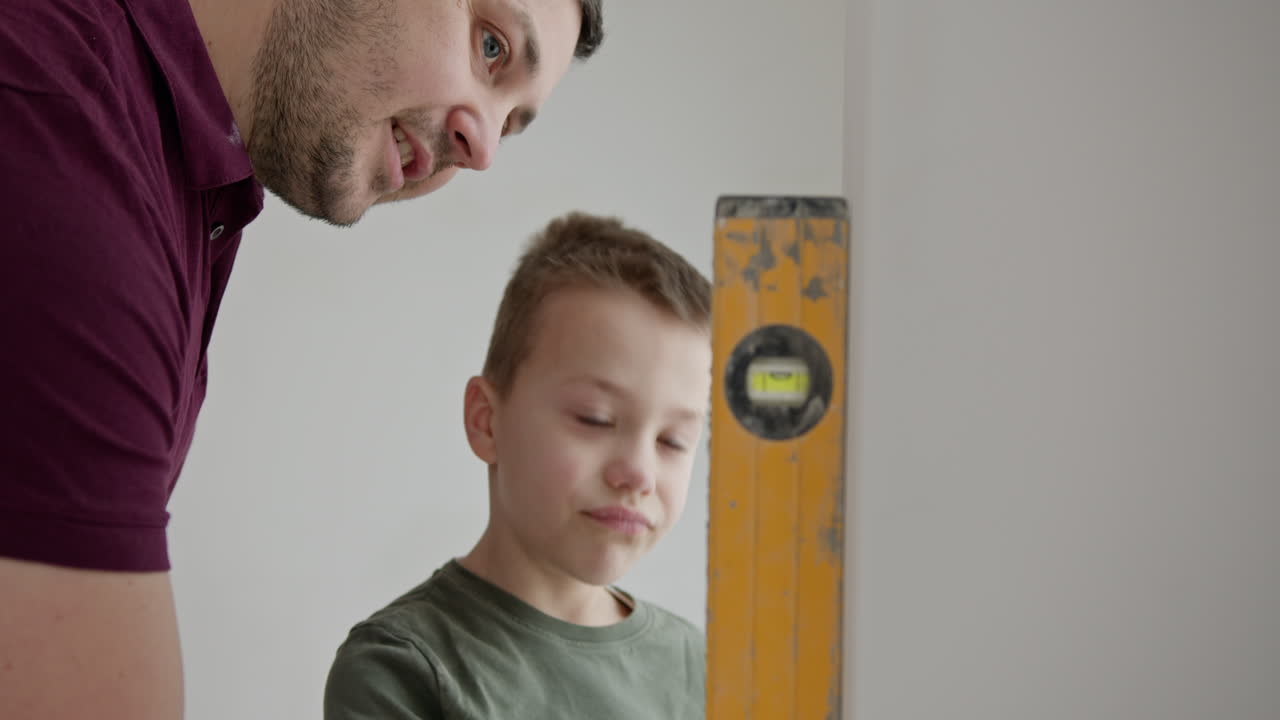 padre e hijo comprobando el nivel de la pared