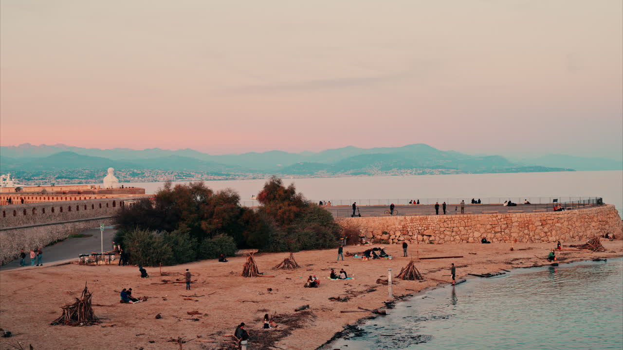 Scenic coastal view of people at a beach Antibes, France at sunset