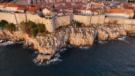 aerial dolly shot pulling away from the ancient walls of dubrovnik, croatia later in the afternoon.