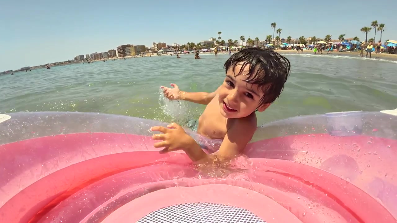 Happy Young Boy Playing on Inflatable Float in the Ocean