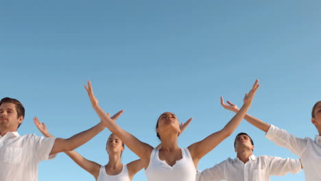 Peaceful-people-practicing-yoga-the-beach