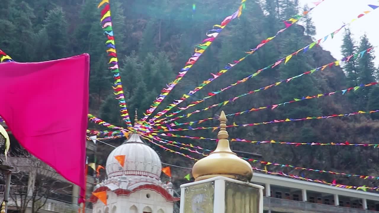 manikaran sahib gurudwara de la religión sikh decorada con banderas durante el día desde diferentes ángulos el video se toma en manikaran manali himachal pradesh india el 22 de marzo de 2023