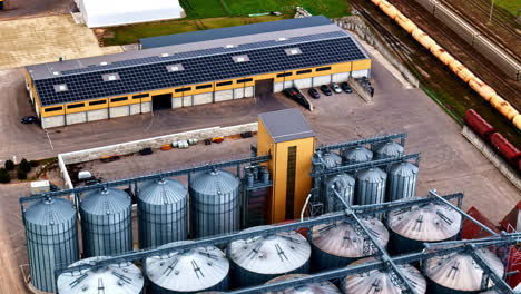 an industrial plant with silos and storage, the roofs of which are covered with solar panels.