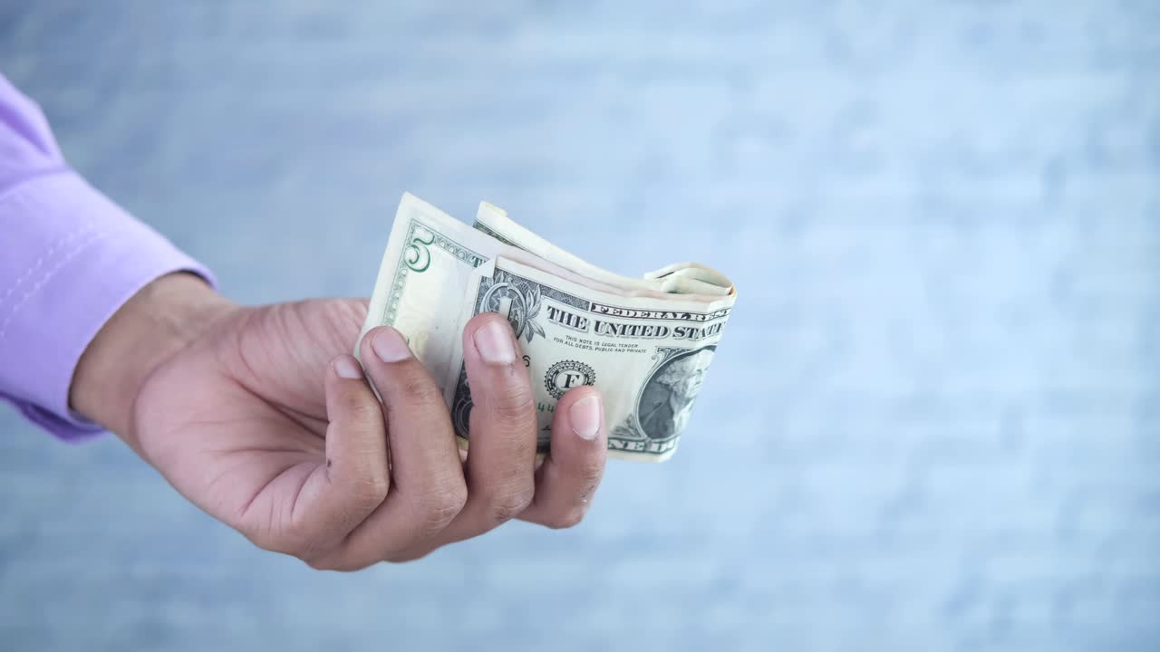 손은 은 5달러 지폐를 들고 있습니다.