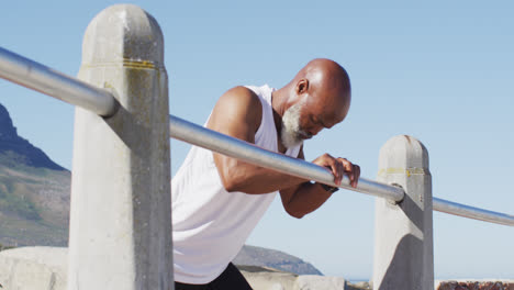 Älterer-Afroamerikanischer-Mann-Trainiert-Dehnübungen-Auf-Felsen-Am-Meer