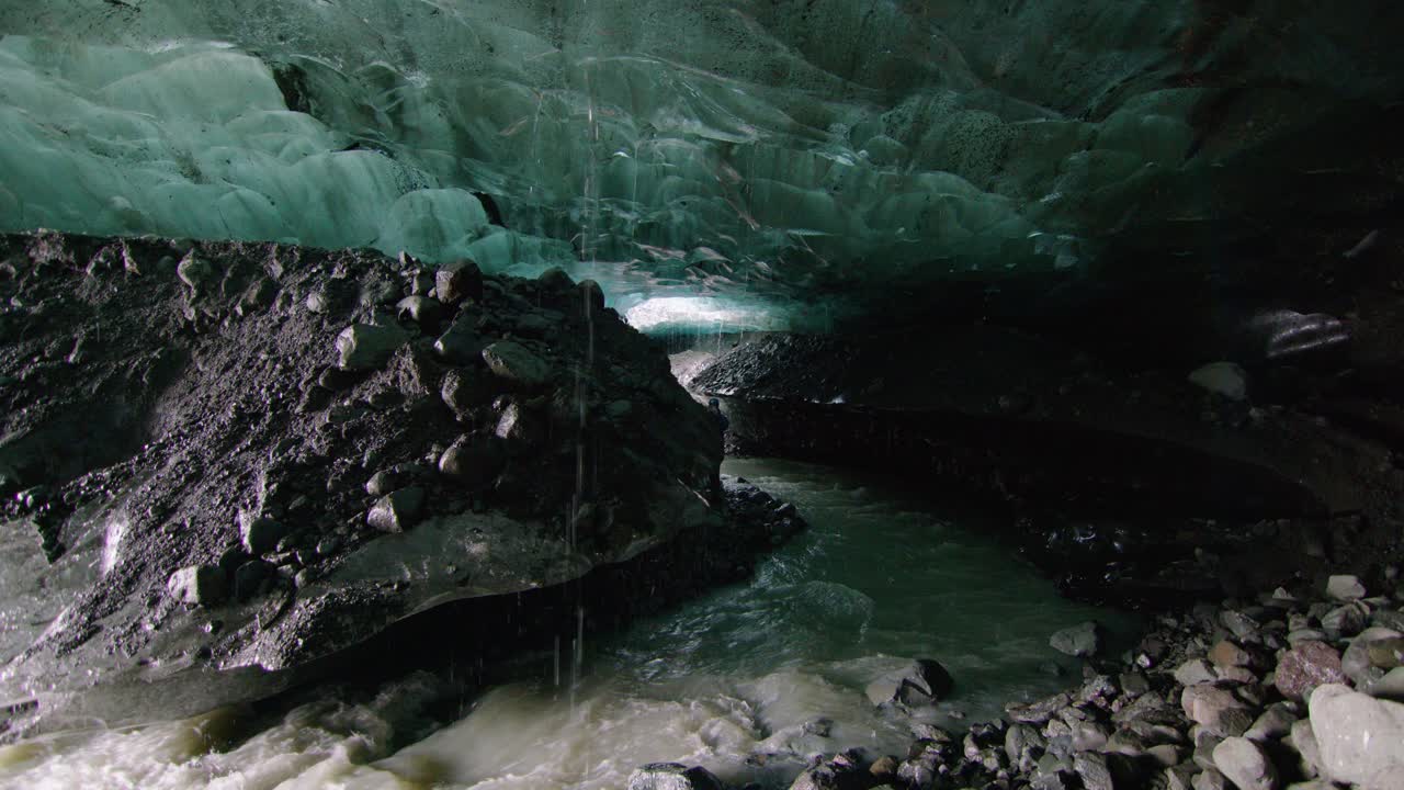 en el borde de una cueva de hielo azul del glaciar con un pequeño arroyo frío en islandia
