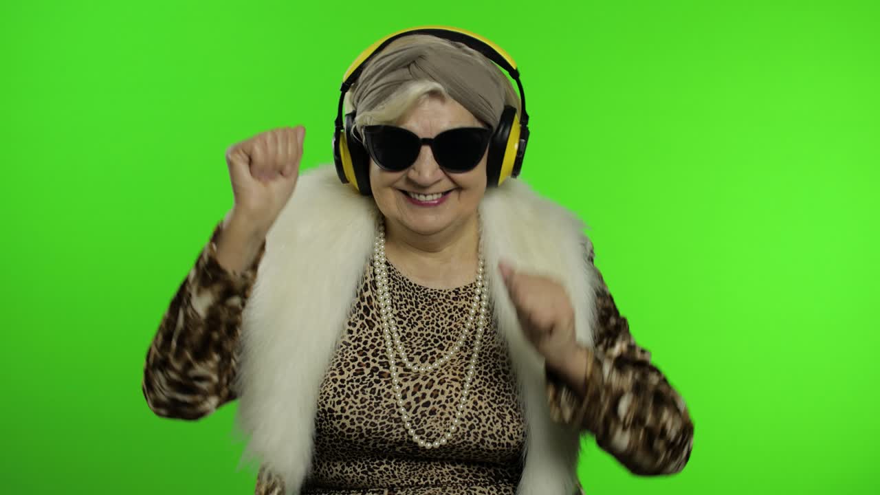 Nonna anziana. Donna caucasica. Balla, festeggia, ascolta musica. Chroma key.