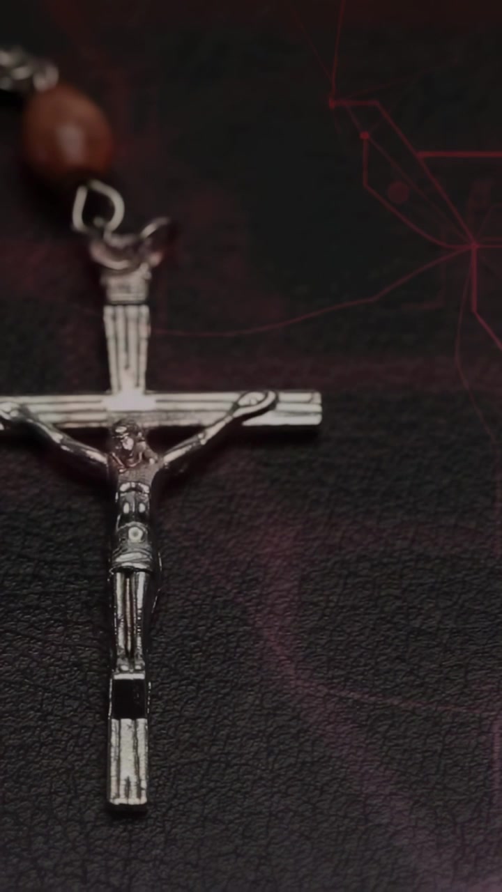 Vídeo vertical: Mão colocando um terço iniciando a transição de foco, crucifixo entrando em foco para um plano fechado