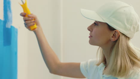 una mujer pintando una pared.