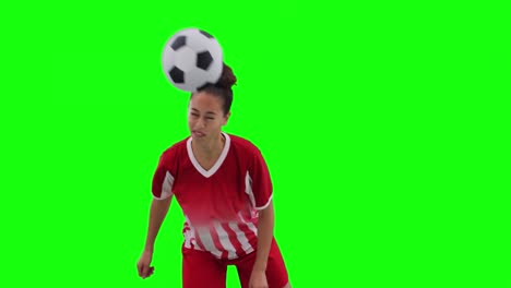 Video-of-caucasian-female-football-player-head-kicking-football-and-copy-space-on-green-screen