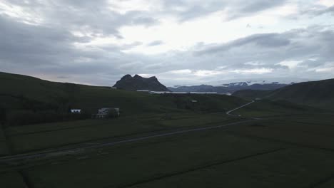 Drone-flight-over-Iceland-fields-along-Ring-Route-1-toward-distant-Vik-mountain