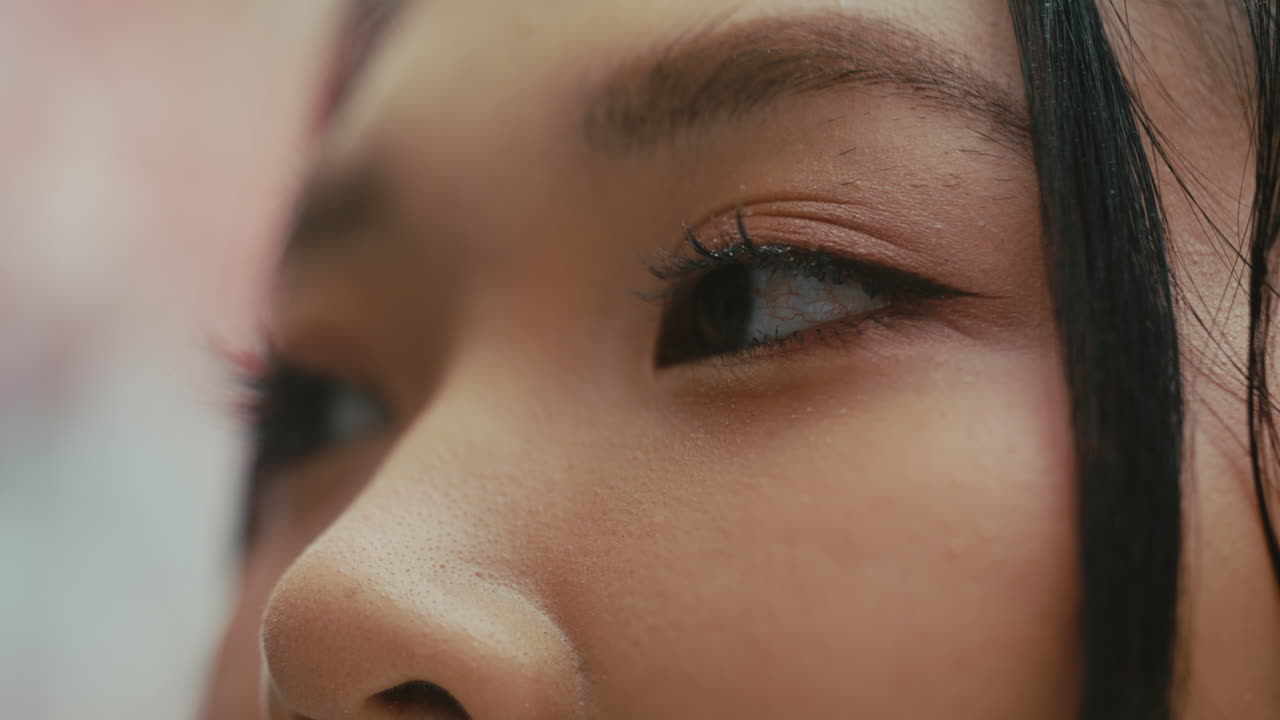 A close-up of an eye with soft lighting, smooth skin texture, and natural makeup