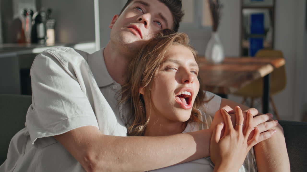 Married couple embracing home in sunlight. Closeup loving partners communicating