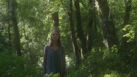 woman standing in a lush green forest